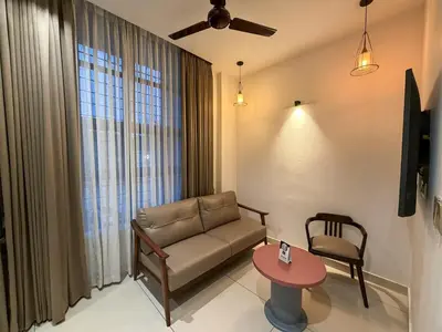 a living room with a couch and a table at Hotel Grand Residency in Mannārakkāt
