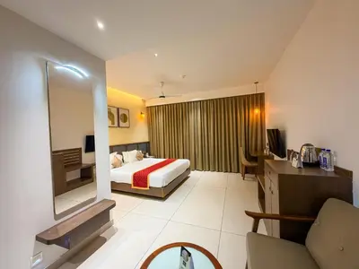 a hotel room with a bed and a mirror at Hotel Grand Residency in Mannārakkāt
