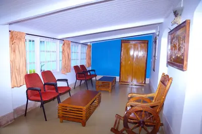 a living room with chairs and a table at Celestial Resorts in Kotagiri