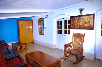 a room with chairs and a table and a painting on the wall at Celestial Resorts in Kotagiri