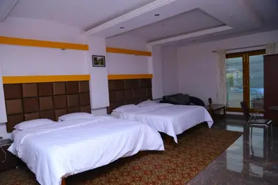 a hotel room with two beds with white sheets at Celestial Resorts in Kotagiri