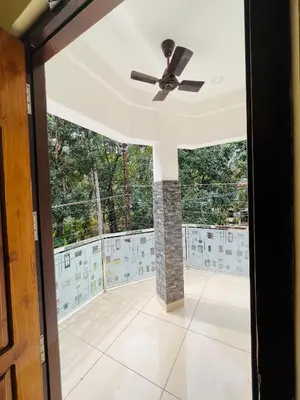 a ceiling fan in a living room with a fireplace at Panakkal Tower in Guruvāyūr