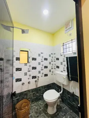 a bathroom with a toilet and a shower at Panakkal Tower in Guruvāyūr