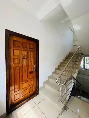 a large wooden door in a room with stairs at Panakkal Tower in Guruvāyūr