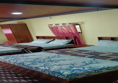 two beds sitting in a room with at Kuruva Heritage Home in Wayanad