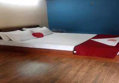 a large bed with a red pillow on top of it at Kuruva Heritage Home in Wayanad
