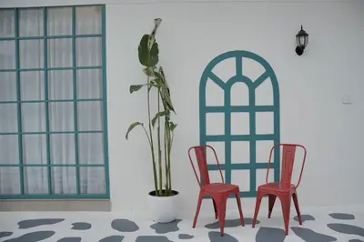 two red chairs and a potted plant in a room at The Soul by VDN A Santorini inspired Villa in Trichūr