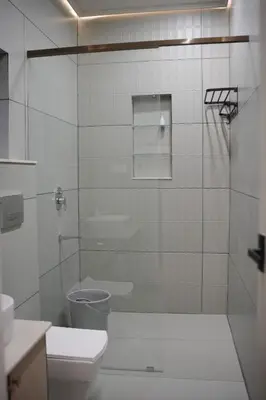 a white bathroom with a toilet and a shower at The Soul by VDN A Santorini inspired Villa in Trichūr