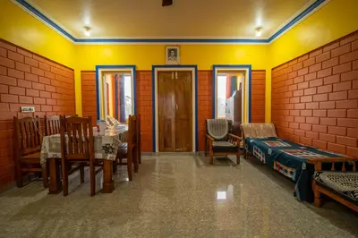 a room with tables and chairs and yellow walls at The Blue Hist in Naduvattam