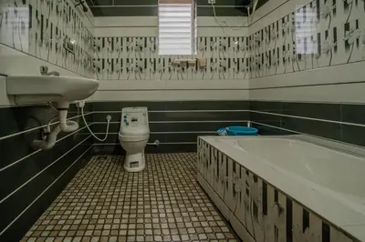 a bathroom with a sink and a tub and a toilet at The Blue Hist in Naduvattam