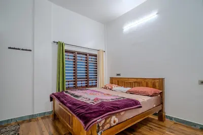 a bed in a room with a window at The Blue Hist in Naduvattam