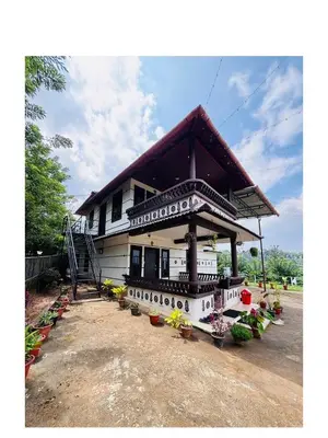 a house with a roof with plants in front of it at Mocha Valley Homestay in Kalpetta