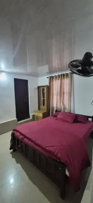 a bedroom with a bed with a red comforter at Mocha Valley Homestay in Kalpetta