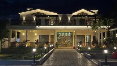 a building with a mural on the front of it at night at Kurunchi malar Resorts in Hosūr