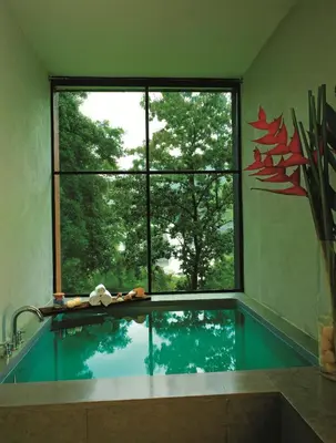 a bathroom with a swimming pool with a large window at Rainforest Resort in Athirappilly