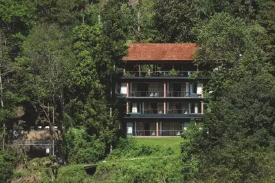 a large building in the middle of a forest at Rainforest Resort in Athirappilly