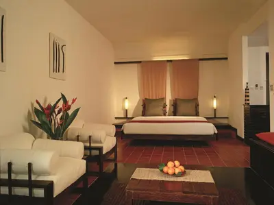 a hotel room with a bed and a living room at Rainforest Resort in Athirappilly