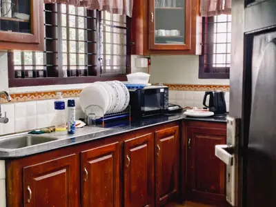 a kitchen with a sink and a microwave at Ambadis Beach View 3BHK Pool Villa in Pallipuram