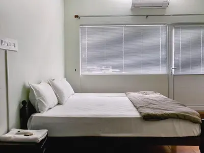 a bedroom with a large bed with a window at Ambadis Beach View 3BHK Pool Villa in Pallipuram