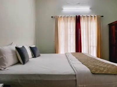 a bedroom with a large bed in front of a window at Ambadis Beach View 3BHK Pool Villa in Pallipuram