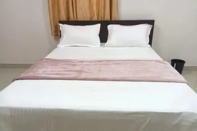 a large white bed with two pillows in a room at Harmony INN Rooms in Palakkad