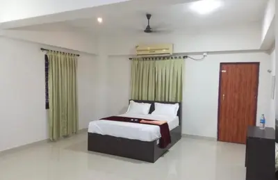 a bedroom with a bed and a wooden door at Harmony INN Rooms in Palakkad