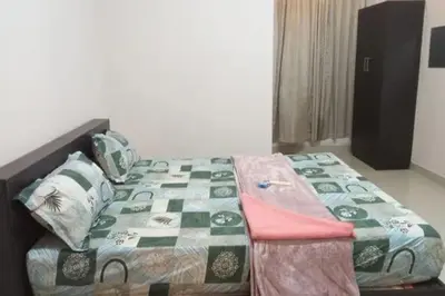 a bedroom with a bed with a blanket on it at Harmony INN Rooms in Palakkad