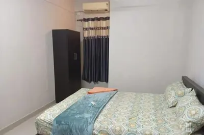 a bedroom with a bed and a dresser in it at Harmony INN Rooms in Palakkad