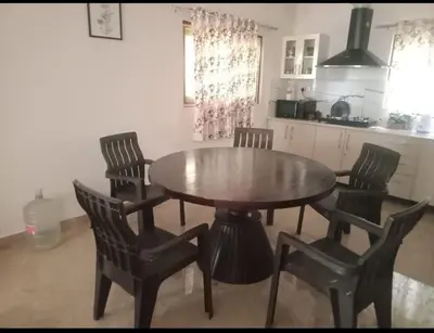 a wooden table and chairs in a kitchen with a table at Merchants Tranquility Home in Vythiri