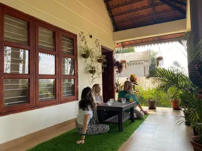a group of people sitting at a table on grass at Merchants Tranquility Home in Vythiri
