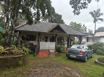 a car parked in front of a house at Merchants Tranquility Home in Vythiri