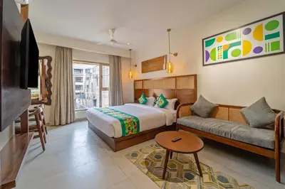 a hotel room with a bed and a couch at Treebo Premium Cachet Suites in Coimbatore