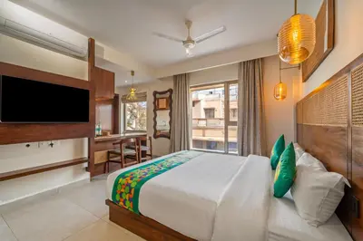 a bedroom with a bed and a television and a desk at Treebo Premium Cachet Suites in Coimbatore
