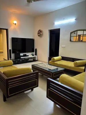 a living room with couches and a flat screen tv at Traditional house near Cochin airport in Chewarra