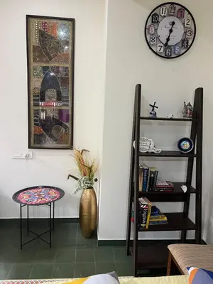 a room with a chair and a clock and a shelf at Traditional house near Cochin airport in Chewarra