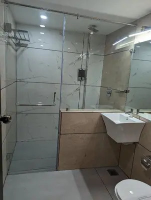 a bathroom with a shower and a sink at Oxyrich Business Class Hotel in Madikeri