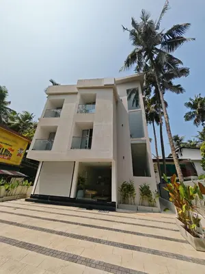 a building with a palm tree in front of it at The Zen Retreat in Kozhikode