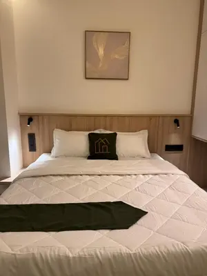 a large white bed with a green pillow on it at The Zen Retreat in Kozhikode