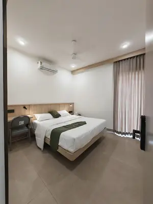 a bedroom with a large bed and a window at The Zen Retreat in Kozhikode