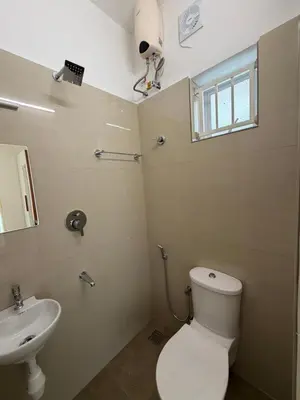 a bathroom with a toilet and a sink at Balcony inn in Nedumbassery