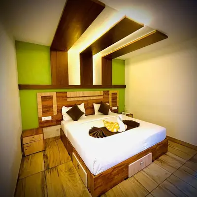 a bedroom with a large bed with green walls at Mountain View A frame Pool Villa in Meppādi