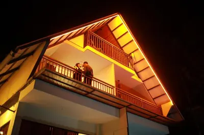 two people standing on a balcony of a building at Mountain View A frame Pool Villa in Meppādi
