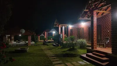 a garden at night with a church in the background at Coffee County in Srimangala