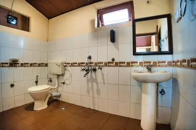 a bathroom with a toilet and a sink and a mirror at Coffee County in Srimangala