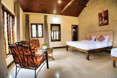 a bedroom with a bed and a chair in a room at Coffee County in Srimangala
