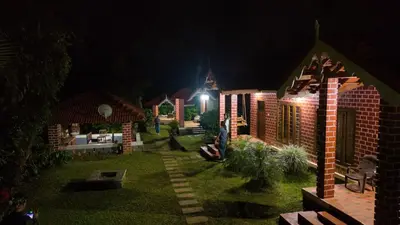 a house with a lit up yard at night at Coffee County in Srimangala
