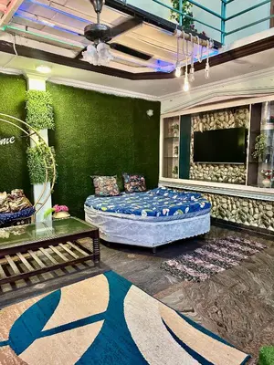 a living room with a bed and a flat screen tv at Mysore City Center Rooms by A1k in Mysore