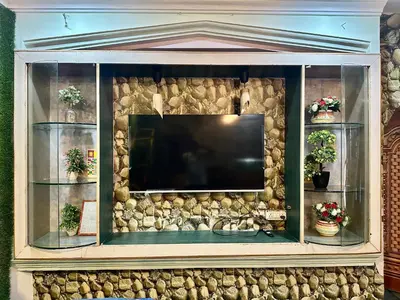a large entertainment center with a flat screen tv at Mysore City Center Rooms by A1k in Mysore