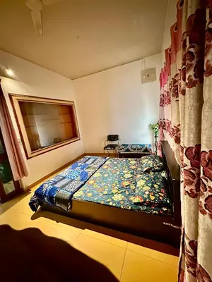 a bedroom with a bed with a colorful quilt at Mysore City Center Rooms by A1k in Mysore