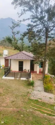a small white house with a tree in a field at Haven heights kanthalloor in Kanthalloor